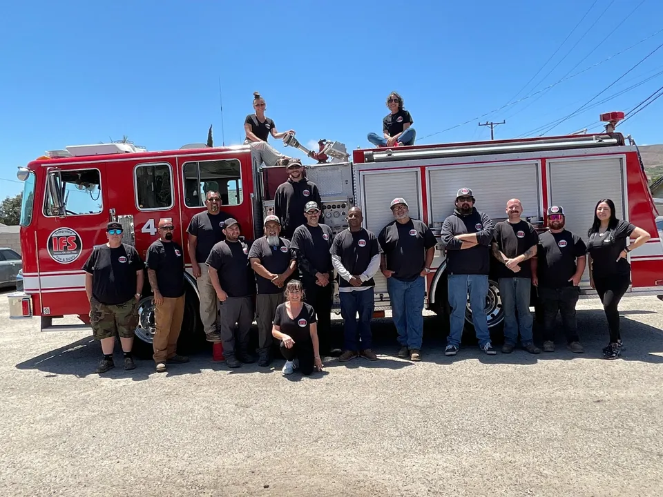 The Integrated Fire & Safety team gathered in front of an IFS fire engine